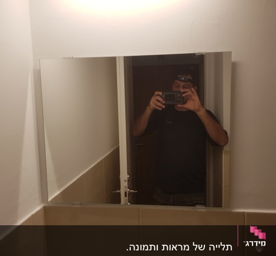 אדם מצלם במראה עם פנס ראש